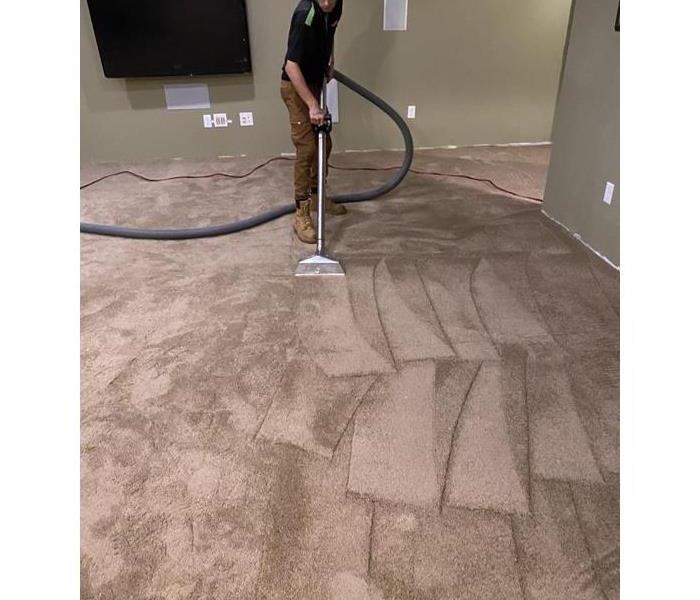 worker extracting water from carpet